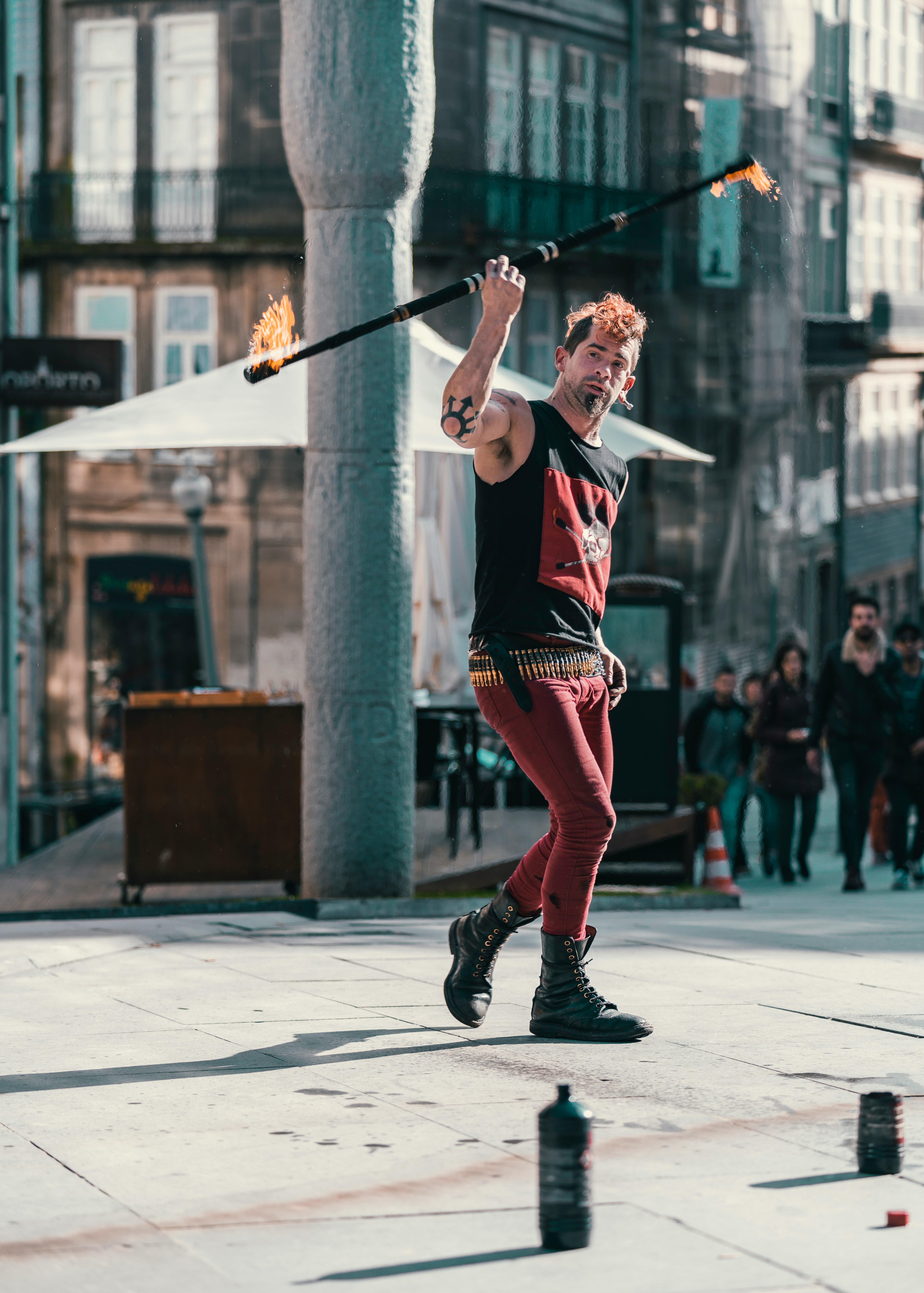 man holding rod fire standing near pillar